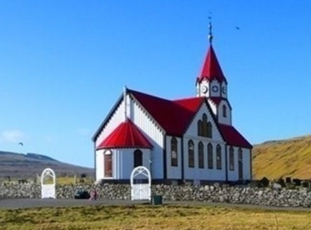 Standmyndin stendur beint við Sandavágs kirkju (Savnsmynd)