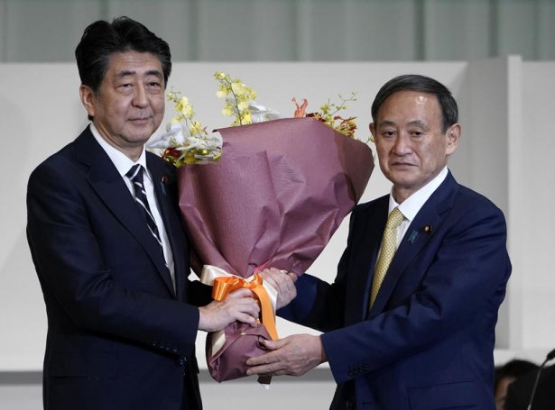 Shinzo Abe, forsætisráðharri handaði Yoshihide Suga blómur, eftir at hann varð valdur til floksleiðara hjá LDP (Mynd: EPA)