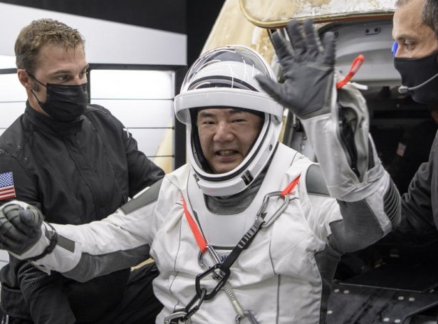 Astronautarnir verða hjálptir út úr rúmdarhylkinum. Her er tað japanin Soichi Noguchi (Mynd: EPA)