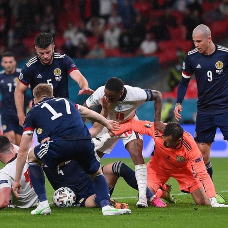 Ímóti endanum líktist tað mestum rugby, tá Declan Rice royndi at fáa bóltin í skotska málið, og McTominay og aðrir royndu at verja fyri (Mynd: EPA)