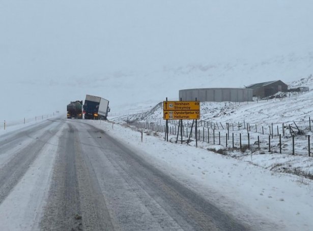 Lastbilur fór fyrrapartin útav vegnum Millum Fjarða. Landsverk arbeiðir við at fáa lastbilin upp aftur.