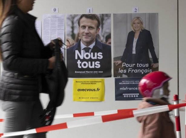 Valið stendur millum Emmanuel Macron og Marine Le Pen. Her sæst ein kvinna á veg at greiða atkvøðu (Mynd: EPA)