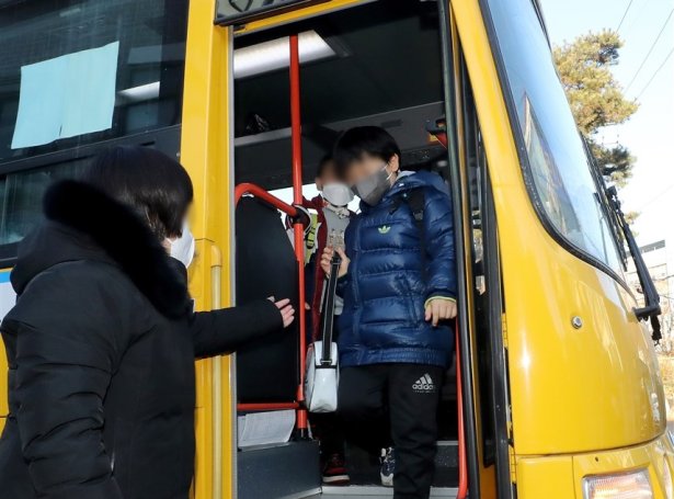 Børn í munnbindi á skúlabussi í Seoul (Mynd: EPA)