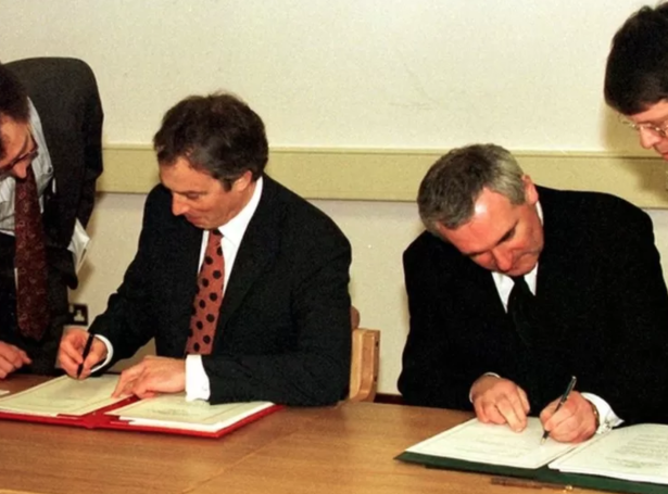 Bretski forsætisráðharrin Tony Blair og írski forsætisráðharrin Bertie Ahern skriva undir avtaluna í 1998.