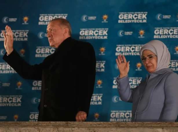 Recep Tayyip Erdogan og kona hansara Emine heilsa veljarunum eftir at valhølini lótu aftur í gjárkvøldið (Mynd: EPA)