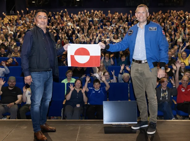 Andreas Mogensen handar grønlendska flaggið, Erfalasorput, sum hann hevði við sær í rúmdini, til stjóran á grønlendska tjóðarsavninum, Daniel Thorleifsen (Mynd; Sermersooq kommuna)