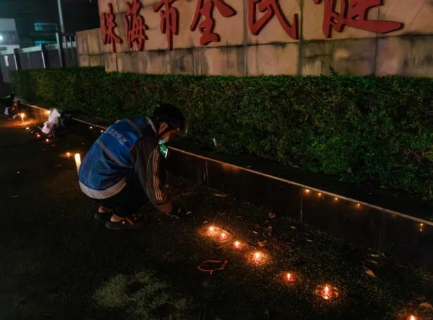 Maður leggur blómur til minnis um tey, sum lótu lív í álopinum í Zhuhai í november (Mynd: EPA)