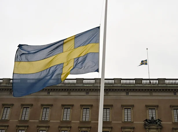 Svenska flaggið á hálvari stong í Stokkhólmi í dag. Soleiðis er ymsastaðni í Svøríki, og ein savnað tøgn í ein minutt verður eisini sett í lag til minnis fyri teimum deyðu í skúlaskjótingini (Mynd: EPA)