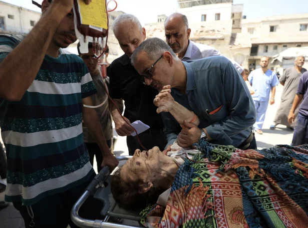 Boðað verður frá, at fleiri fólk vórðu særd í álopinum á katólsku kirkjuna í Gaza. Her sæst ein kvinna, sum verður flutt á sjúkrahús eftir álopið (Mynd: Reuters)