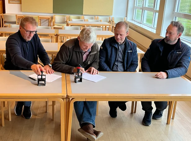 Andrass Holm Arge og Tróndur Leivsson, frá Búnaðarstovuni og John Zachariassen og Mads Helgi Poulsen frá Munin skriva undir avhendingarskjalið fyri Talgildu Landsjarðarskipanina