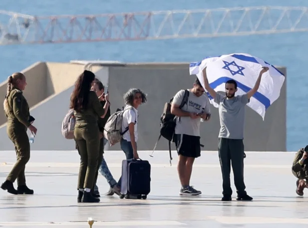 Ein av leyslatnu gíslunum, Nimrod Cohen, veittrar við ísraelska flagginum eftir at vera komin úr tyrluni á takinum á Ichilov sjúkrahúsinum í Tel Aviv (Mynd: EPA)