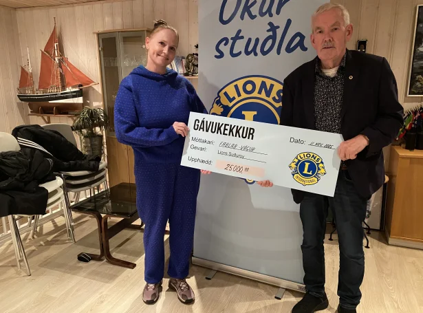 Tina Grønbech, leiðari á Fab-Lab í Vági tekur ímóti kekkinum frá Bent Albinus, forseta í Lions Suðuroy til sermerktu og slóðbrótandi verkætlanina, tey eru farin undir