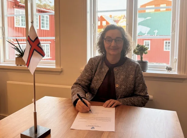 Sirið Stenberg, landsstýriskvinna í uttanríkis- og vinnumálum skrivar undir umsóknina til WTO limaskap