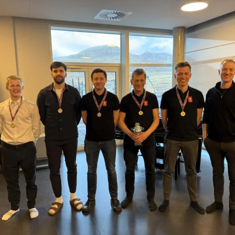 FM-manningin hjá Sandavágs Talvfelag 2026: F.v.: Jón í Horni Nielsen, Silas Eyðsteinsson, Høgni Egilstoft Nielsen, Torkil Nielsen og Rógvi Egilstoft. Ytstur høgrumegin sæst Bjarni Prior, borgarstjóri í Vága Kommunu. (Mynd: Jn.fo)