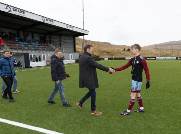 Tað var pápi Sjúrð, Rói Henriksen, saman við Sjúrði Olsen, stjóra í Bygma Balslev, og Hera á Rógvi, starvsnevndarlimi í FSF, sum vegna Fótbóltssamband Føroya handaðu Sjúrði Henriksen eitt gávubræv uppá 1.000 krónur frá Atlantic Airways, og eina heiðursplátu, ið er latin av FSF (Mynd: Finnur Justinussen/fsf.fo)