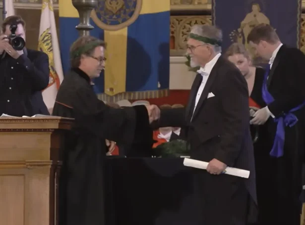 Hátíðardámur inni í dómkirkjuni í Lund, har promotorurin á latíni handaði Jóan Paula Joensen krans og diplom