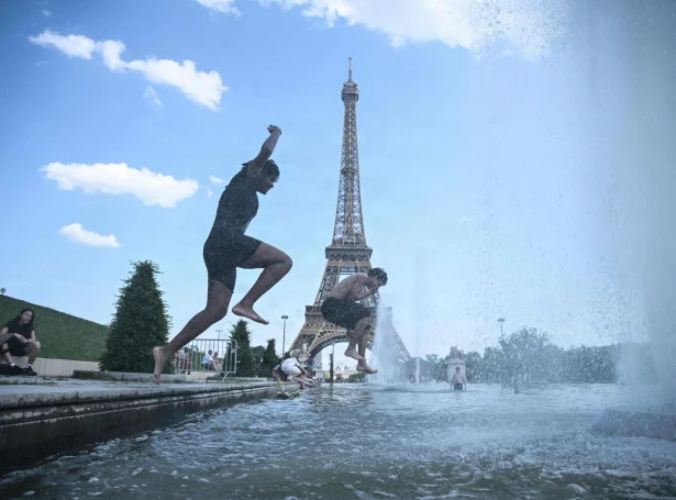 Í Paris leypa fólk í Trocadero gosbrunnin nærhendis Eiffel torninum fyri at køla seg niður (Mynd: Julien De Rosa/AFP/Ritzau Scanpix)