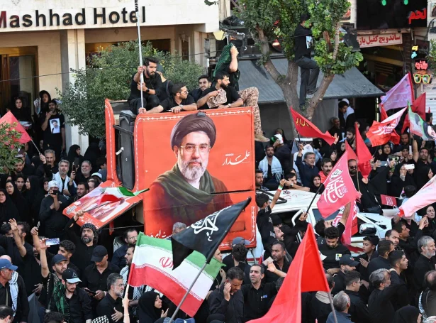 Syrgjandi iranar í Mashhad, har Ali Khamenei varð jarðaður fríggjadagin, síggjast her saman við mynd av Mojtaba Khamenei (Mynd: Wakil Kohsar/AFP/Ritzau Scanpix)