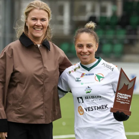 Randi Hilmarsdóttir Thomassen, forkvinna í kvinnunevndini í 07 Vestur, handaði vegna Fótbóltssamband Føroya Evelin eitt gávubræv frá Bygma Balslev, og eitt heiðurstekin, ið er latið av FSF (Mynd: Hans Erik Danielsen/FSF)