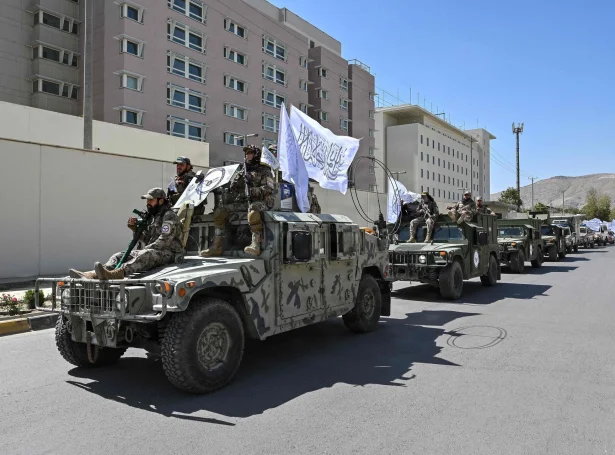 Fólk hjá Taliban hátíðarhalda fimm ára dagin uttanfyri bygningin, sum fyrr hýsti amerikonsku sendistovuna í Kabul (Mynd: Wakil Kohsar/AFP/Ritzau Scanpix)