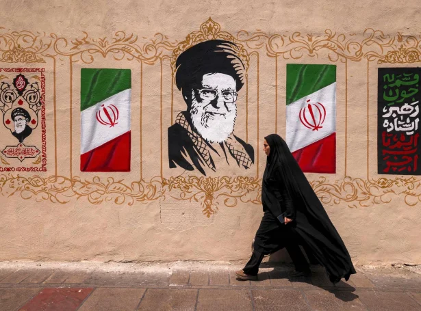 Iransk kvinna gongur framvið veggmálningi av fyrrverandi leiðaranum í Iran, Ali Khamenei (Mynd: Atta Kenare/AFP/Ritzau Scanpix)